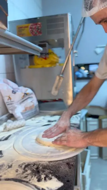 Pizzaiolo abrindo a massa à mão